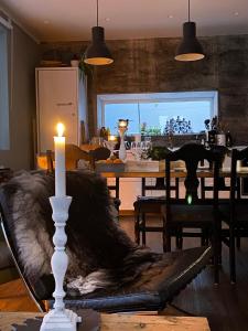 una candela seduta su un tavolo in sala da pranzo di Melar Guesthouse a Kópasker