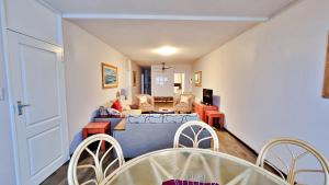 ein Wohnzimmer mit einem Sofa, einem Tisch und Stühlen in der Unterkunft Summerhill Self-Catering Holiday Accommodation in Plettenberg Bay