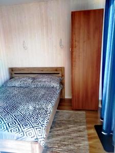 1 dormitorio con 1 cama y puerta de madera en Gospodarstwo Agroturystyczne Andrzejówka, en Gardzień