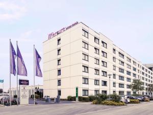 a white building with a sign on top of it at Mercure Hotel Frankfurt Eschborn Ost in Eschborn