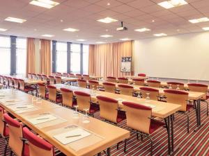 Mercure Hotel Frankfurt Eschborn Ost في إشبورن: قاعة اجتماعات كبيرة مع طاولات وكراسي