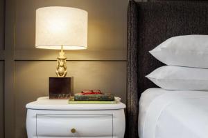 a lamp on top of a nightstand next to a bed at Andaz Savannah - A Concept by Hyatt in Savannah
