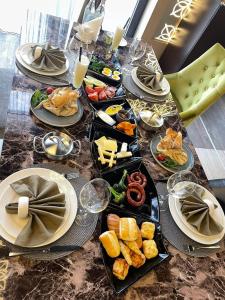 Hills Resort Hotel في يريفان: طاولة طويلة عليها أطباق من الطعام