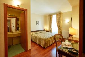 a hotel room with a bed and a bathroom at Liberty Hotel in Turin