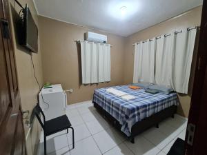 a small bedroom with a bed and a television at Pousada Meireles Praia in Fortaleza