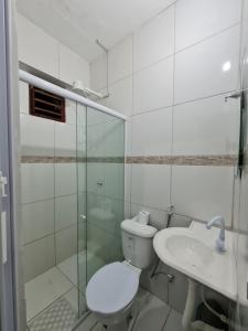 La salle de bains blanche est pourvue de toilettes et d'un lavabo. dans l'établissement Pousada Meireles Praia, à Fortaleza