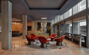 a waiting room with red chairs and a table at Hyatt Regency Zurich Airport Circle in Kloten