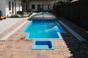 a swimming pool in a backyard with a glass roof at Horehronský dvor in Závadka nad Hronom