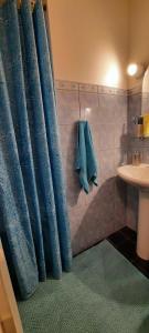 a bathroom with blue shower curtains and a sink at Lennuki Apartement in Rakvere