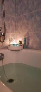 a bathroom with a bath tub with a candle on it at Lennuki Apartement in Rakvere