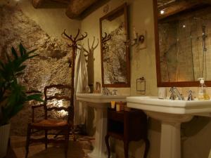 een badkamer met 2 wastafels en een stoel bij La Vita Dolce, Luberon in Grambois