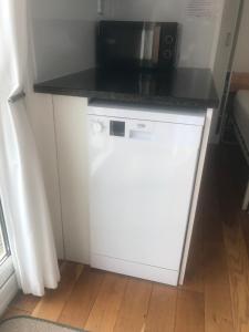 a microwave sitting on top of a white dishwasher at The Retreat in Charmouth