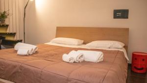 ein großes Bett mit zwei Kissen und Handtüchern darauf in der Unterkunft Apollo Suites in Lecce