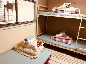 a room with two bunk beds and a window at IM guest house in Osaka