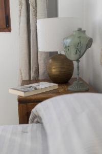 a bedside table with a lamp and a book at Titan, edificio Hipercor, con Parking in Huelva