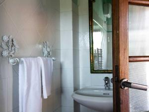 a bathroom with a sink and a toilet and towels at Villa Rosa Panzano in Panzano