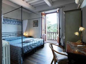 a bedroom with a canopy bed and a window at Villa Rosa Panzano in Panzano
