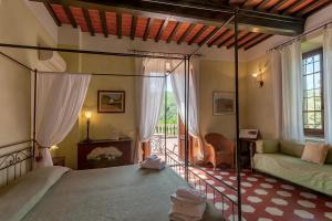 ein Schlafzimmer mit einem Bett und einem Sofa in einem Zimmer in der Unterkunft Villa Rosa Panzano in Panzano