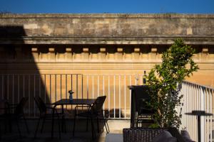 patio ze stołem, krzesłami i ogrodzeniem w obiekcie Apollo Suites w mieście Lecce