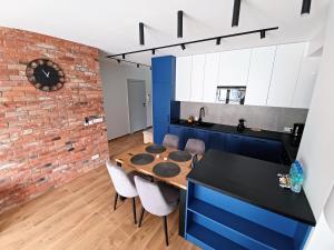 una cucina e una sala da pranzo con parete in mattoni di Kima Apartament Bażantów 44 a Katowice