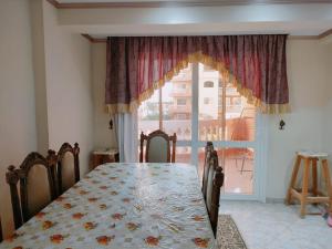 Super Deluxe apartment with 3 Bed rooms في شرم الشيخ: غرفة طعام مع طاولة ونافذة كبيرة