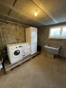 eine Waschküche mit einer Waschmaschine und einem Kühlschrank in der Unterkunft AVEL VAEZ - Charmante maison à 2 pas de l'Aber Wrach in Landéda