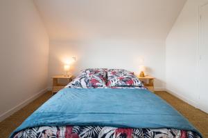 ein Schlafzimmer mit einem Bett mit einer blauen Decke darauf in der Unterkunft AVEL VAEZ - Charmante maison à 2 pas de l'Aber Wrach in Landéda