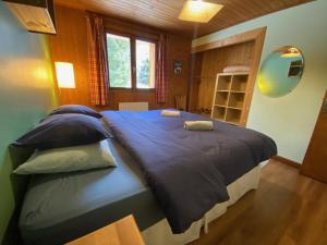 um quarto com uma cama grande com lençóis e almofadas azuis em B&B Chalet Les Frenes em Chamonix-Mont-Blanc
