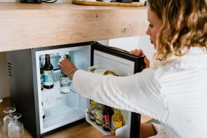 Eine Frau greift in einen offenen Kühlschrank. in der Unterkunft Uitgerust voor Zaken in Heerenveen