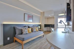 a living room with a blue couch with pillows at SAN MARINO SUITES HOTEL By NOBILE in Goiânia