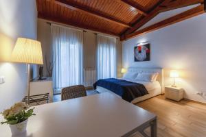 um quarto com uma cama e uma mesa num quarto em Dalmati House San Lorenzo em Roma