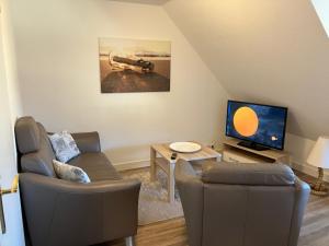 a living room with two chairs and a television at Ferienwohnung 3 ADA in Bergen auf Rügen