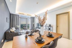 uma sala de jantar e sala de estar com mesa e cadeiras em 2 BR Superior High Floor Apartment in Paramount Midtown, Burj Khalifa View em Dubai