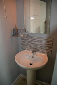 a bathroom with a white sink and a mirror at The Coach House at Copper Hall in Leominster