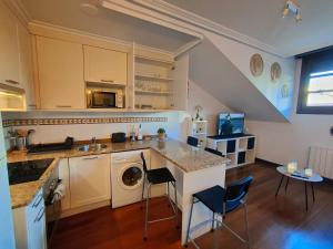 a kitchen with a sink and a dishwasher at El Cielo de Fomento in Gijón
