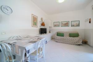 ein Wohnzimmer mit einem Tisch und einem Sofa in der Unterkunft Casa Felice a Porto Azzurro - Goelba in Porto Azzurro