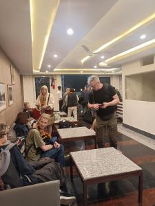 a man standing in a room with a group of people at Hotel Rajwada palace in Orchha