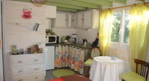 a small kitchen with a table and a kitchen with a kitchen at Les Chambres de Kerzerho in Erdeven