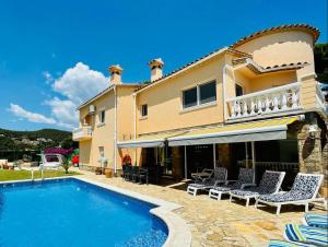 eine Villa mit einem Pool und einem Haus in der Unterkunft Villa reina by costabravaway in Calonge
