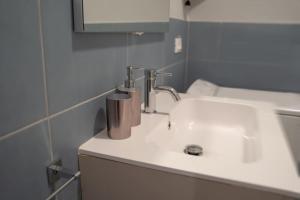ein Badezimmer mit einem weißen Waschbecken und einem Spiegel in der Unterkunft Carlo Residence in Triest