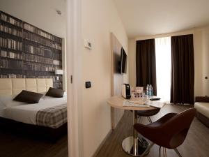 une chambre d'hôtel avec un lit, une table et des chaises dans l'établissement Duomo Hotel & Apartments, à Milan