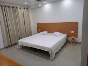 - une chambre avec un lit blanc et une tête de lit en bois dans l'établissement Pull Up, à Praia