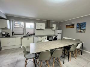 a kitchen with a table and chairs in a room at Willa Hańcza in Smolniki