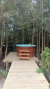 una terraza de madera con bañera de hidromasaje y banco en Cabañas Los Zorzales, en Puerto Montt