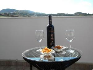 uma mesa de vidro com uma garrafa de vinho e dois copos em Casa Karavola in Galanado village-Naxos em Galanádhon