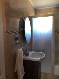 y baño con lavabo y espejo. en Cabañas Los Zorzales, en Puerto Montt