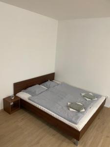 ein Schlafzimmer mit einem Bett und einem Nachttisch in der Unterkunft AA Apartman in Kaposvár