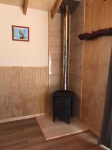 a wood stove in a room with wooden walls at Cabañas Los Zorzales in Puerto Montt