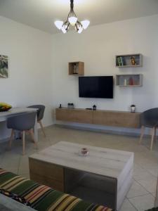 uma sala de estar com um sofá e uma televisão na parede em Casa Karavola in Galanado village-Naxos em Galanádhon