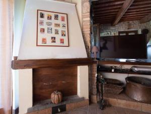 a fireplace in a living room with a tv at Villa I Camini - Outbuilding, dependance - Swimming pool - Garden - BBQ and fireplaces - Soccer field in Monte Castello di Vibio